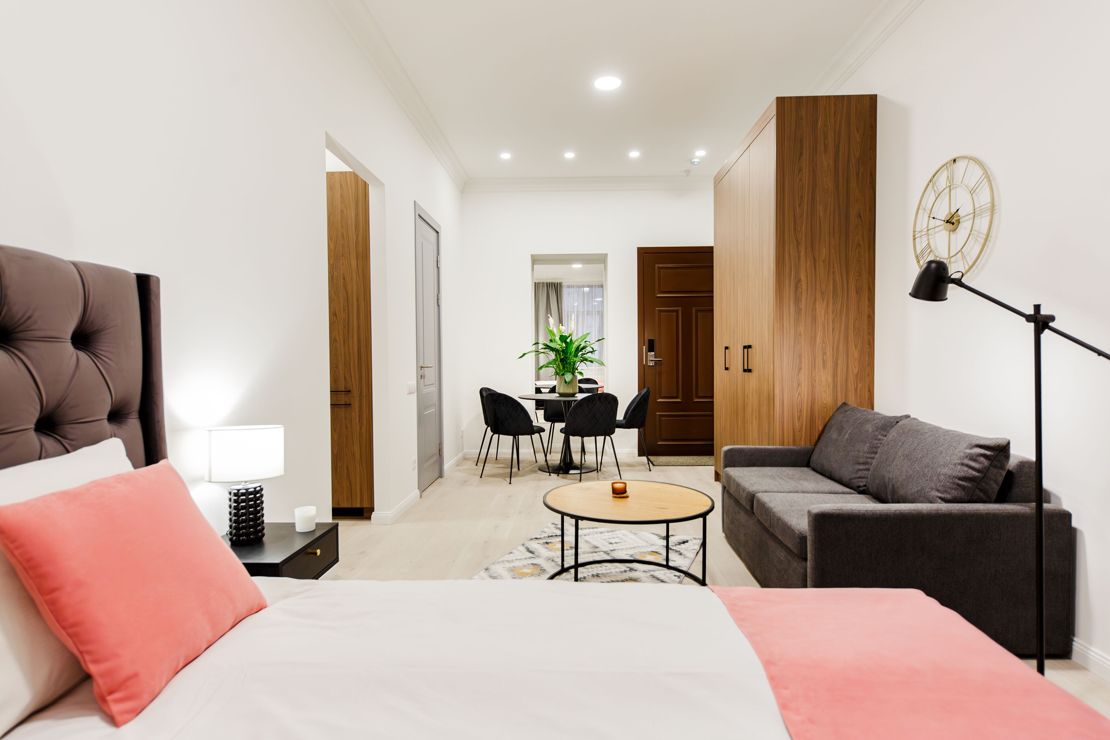 Et moderne hotelværelse med seng, sofa, skrivebord og spiseplads.