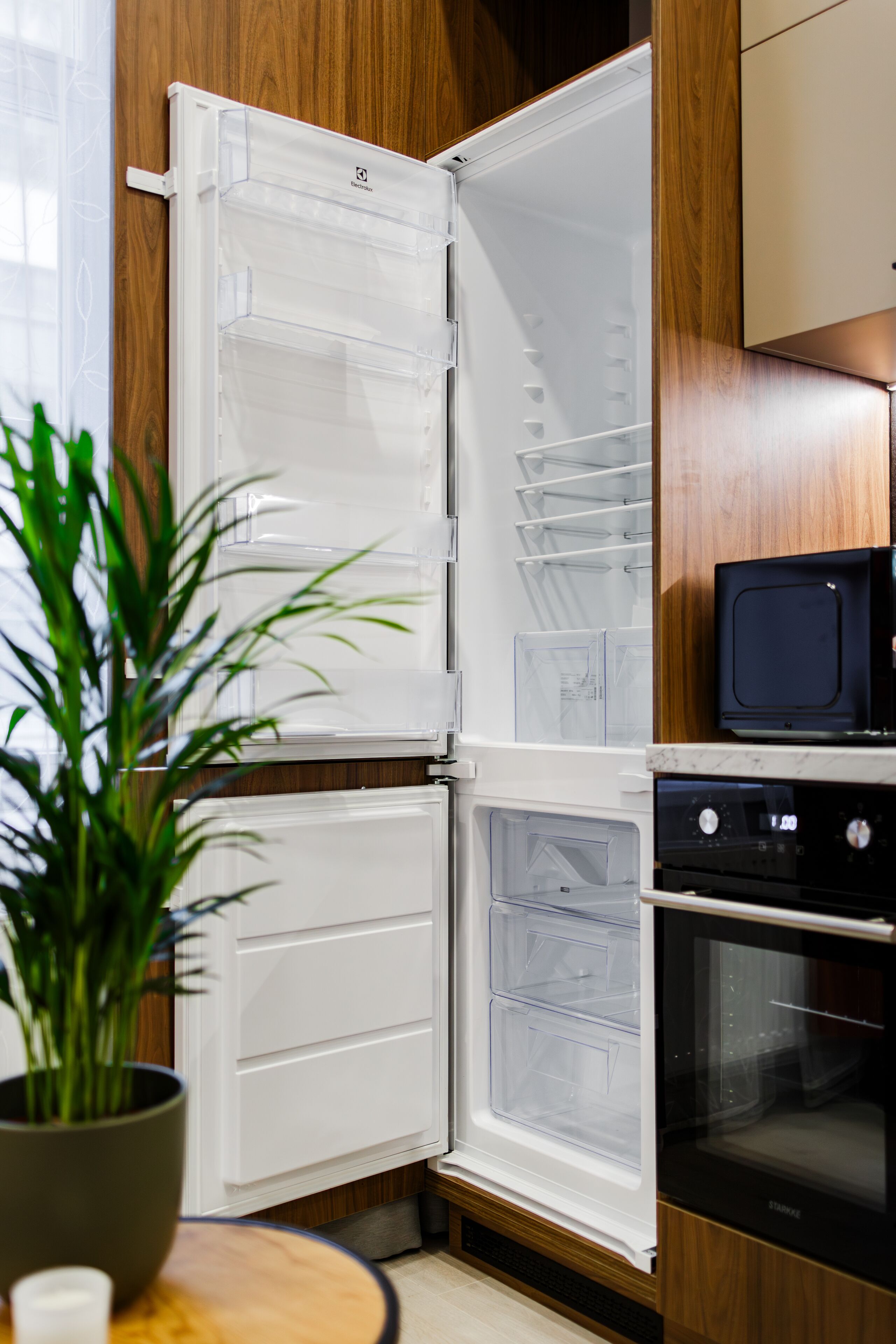 A kitchen with a refrigerator, microwave, and oven.