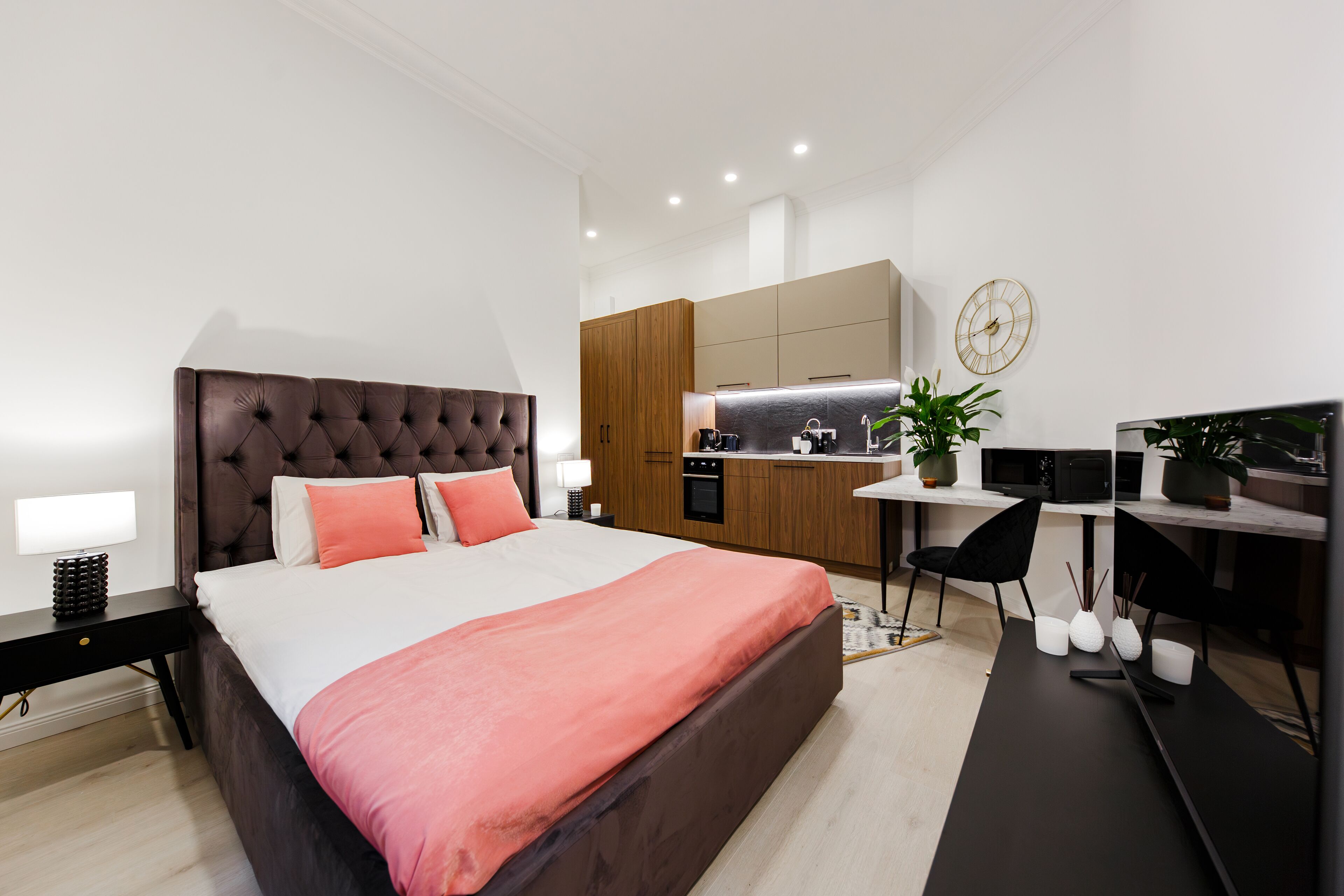 Une chambre moderne avec un grand lit, un bureau et un coin cuisine.