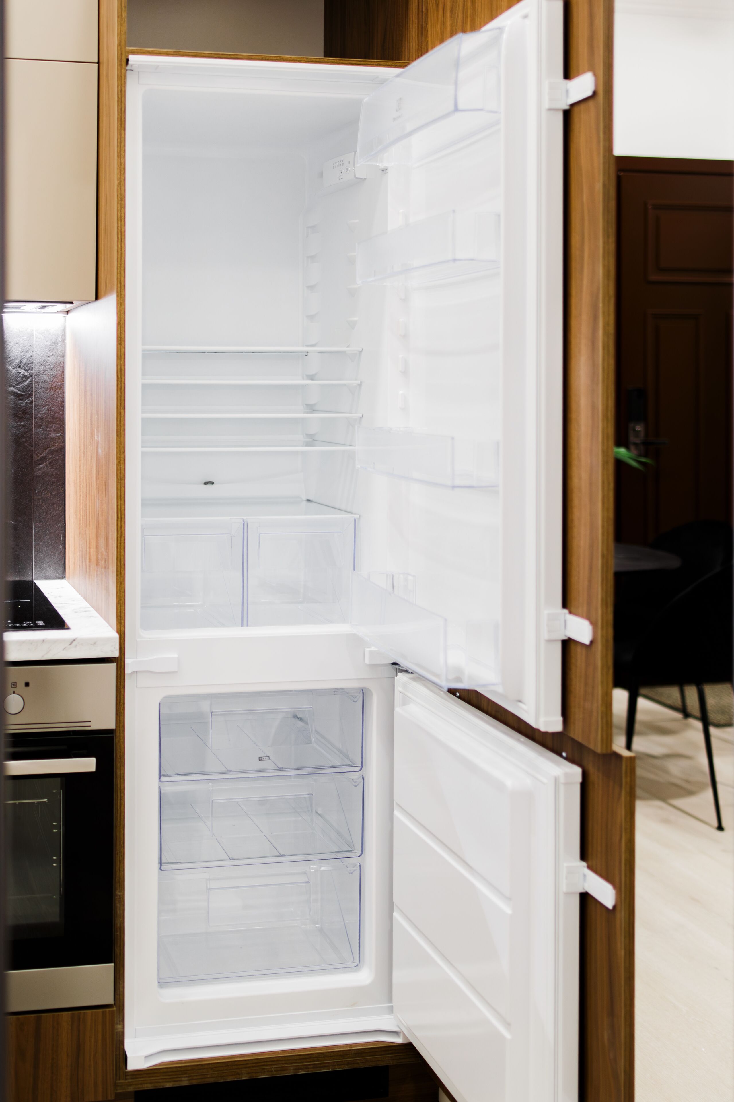 An open refrigerator with multiple shelves and a freezer compartment.