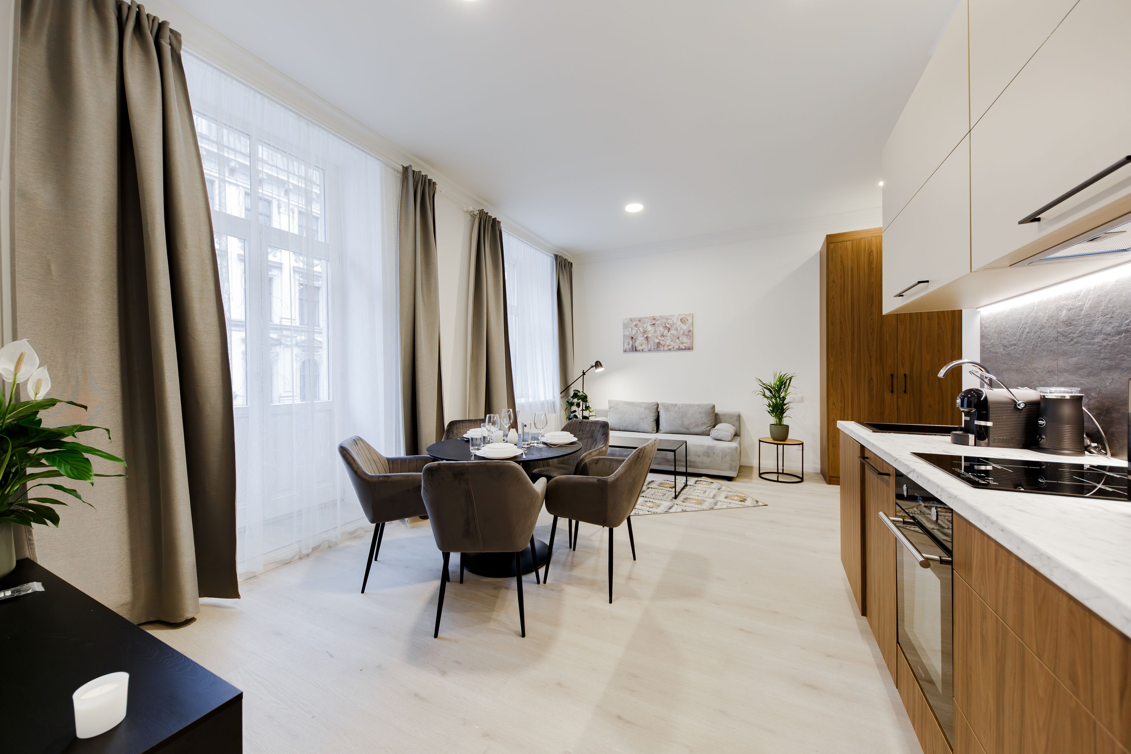 A modern kitchen with a central island, wooden cabinets, and a built-in oven.