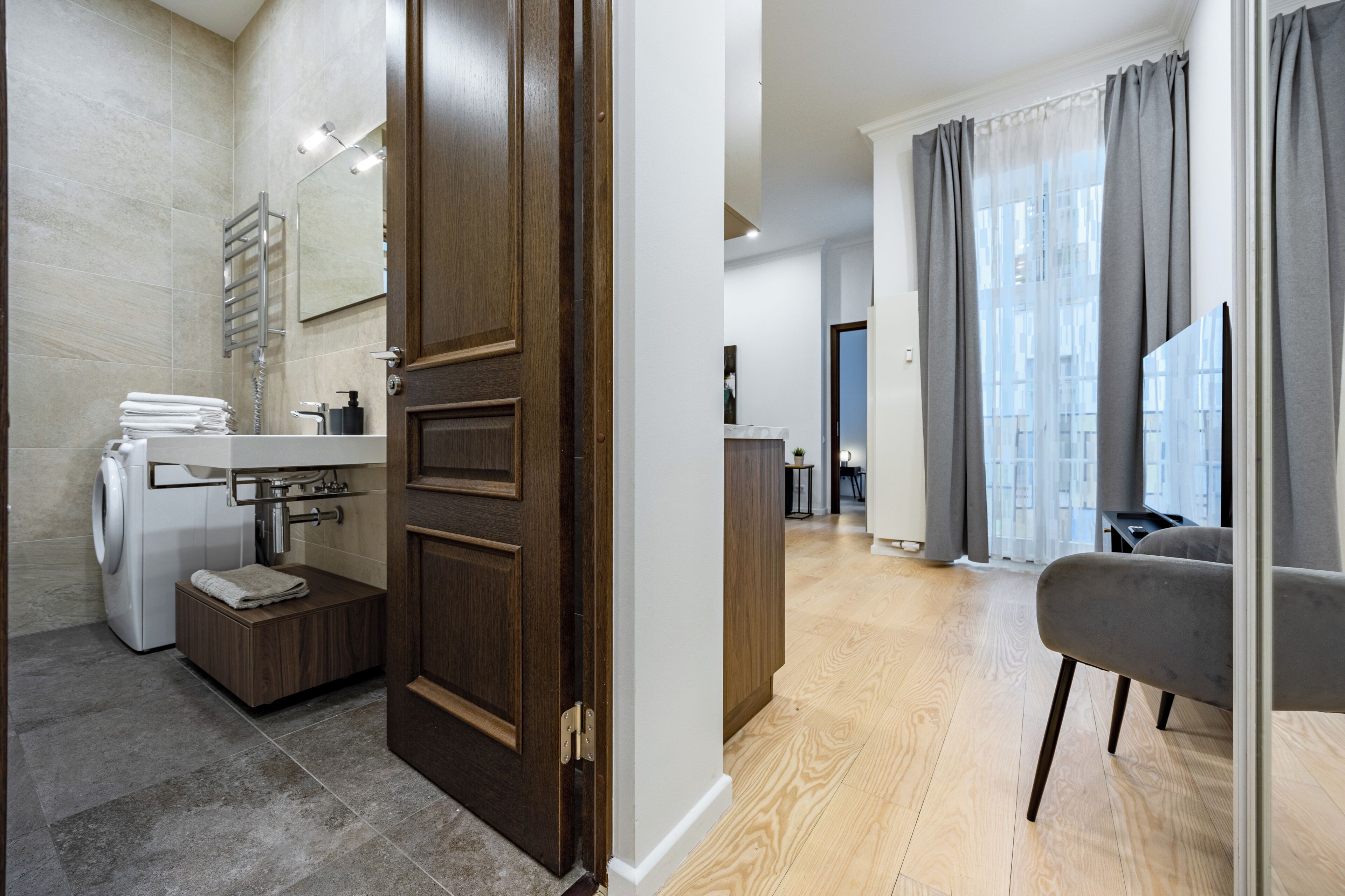 Un baño moderno con lavadora, un perchero y un mueble de madera.