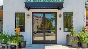 A Starbucks store with a white facade, large windows, and a prominent green sign.