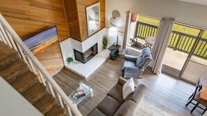 A modern living room with a fireplace, a sofa, a coffee table, and a TV.