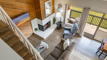 Una sala de estar moderna con chimenea, un sofá, una mesa de centro y un televisor.