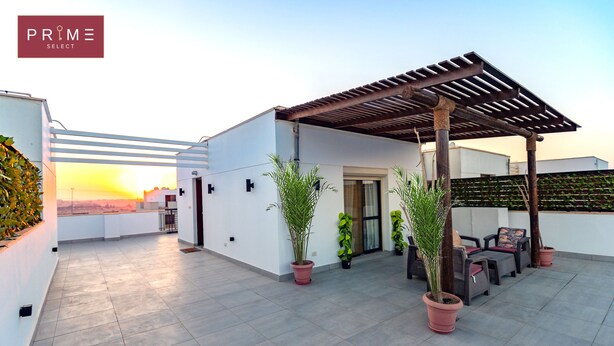 A rooftop terrace with a pergola, potted plants, and outdoor seating.