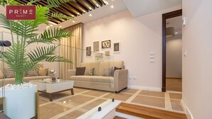 A modern living room with a sofa, coffee table, and a staircase leading to another room.