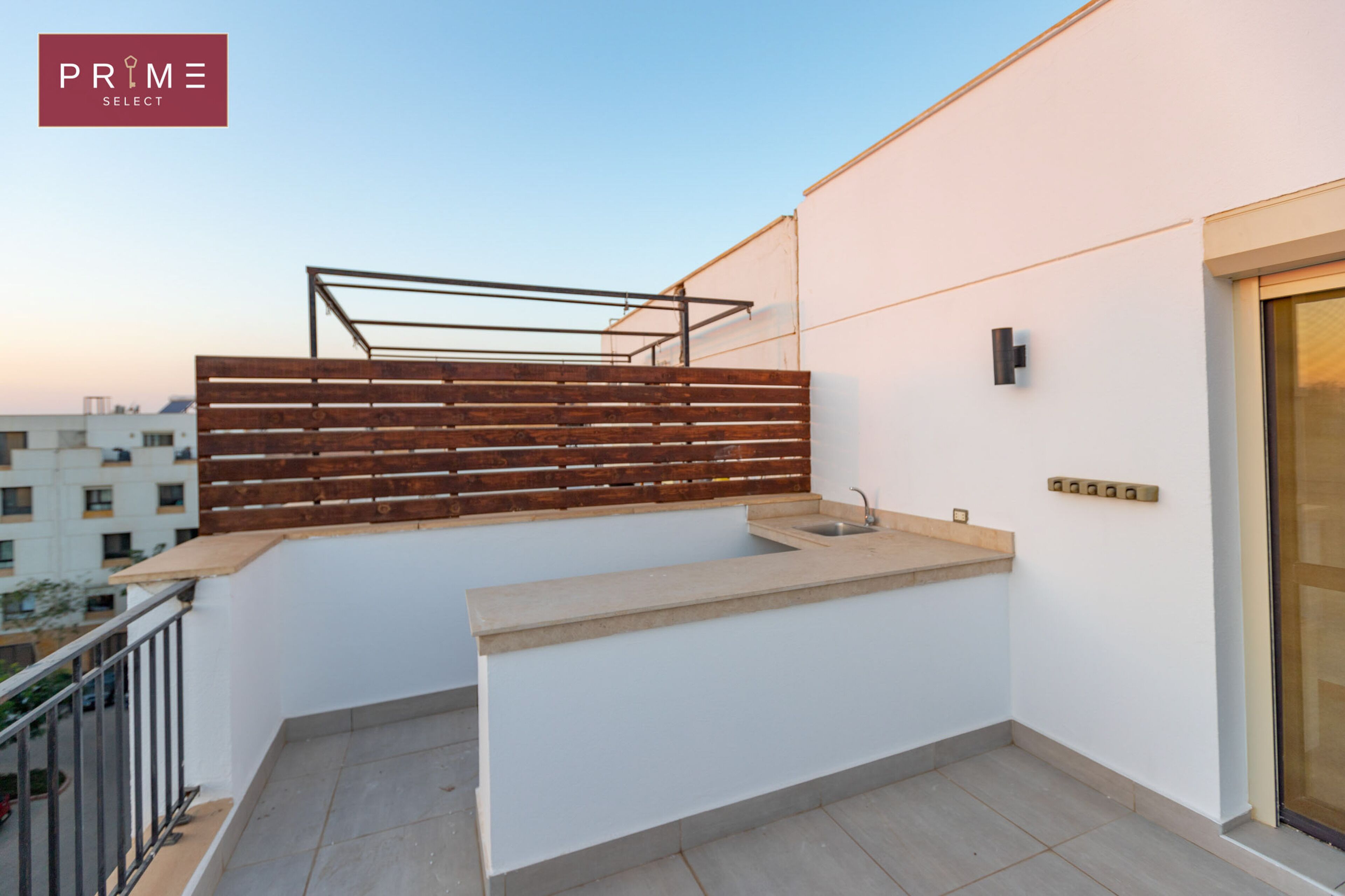 A balcony with a wooden fence, a sink, and a modern light fixture.