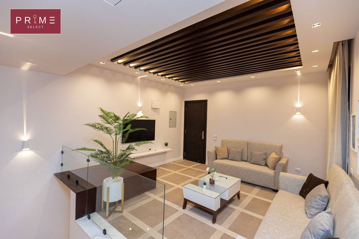 A modern living room with a sofa, coffee table, and a TV.