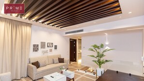 A modern living room with a sofa, coffee table, and a plant.