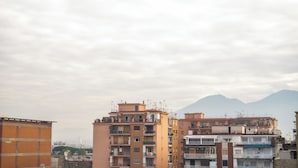 Un immeuble résidentiel à plusieurs étages, doté de balcons et d’antennes paraboliques.