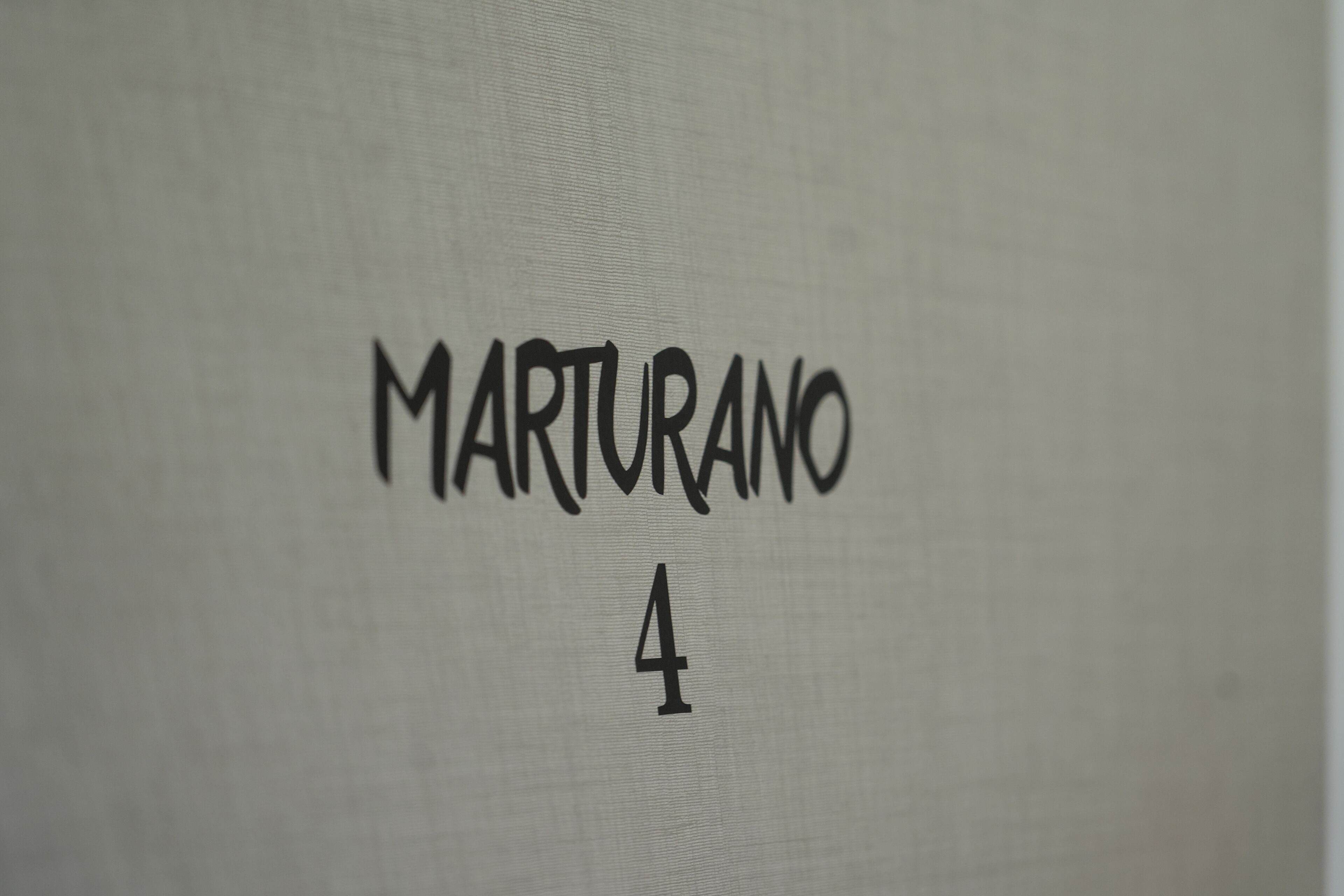 Ein Detailaufnahme einer Wand mit dem Schriftzug 'MARTURANO 4'.
