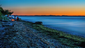 A beach with a rocky shoreline and a calm sea.