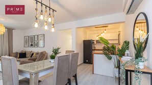 A modern apartment with a dining area, kitchen, and living space. - Prime Select Galleria moon valley (New Cairo)