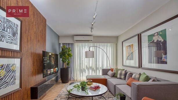 A modern living room with a sofa, coffee table, and artwork. - Prime Select Galleria moon valley (New Cairo)
