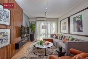 Un salon moderne avec un canapé, une table basse et des œuvres d’art.