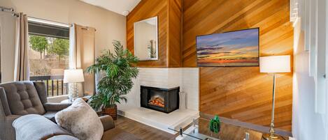 Smart-tv, eldstad och ett bordtennisbord