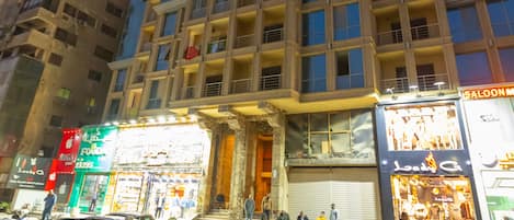 Un edificio de varios pisos con fachada moderna, que cuenta con balcones y ventanas amplias.