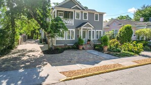 A two-story house with a front porch, a driveway, and a well-maintained garden.