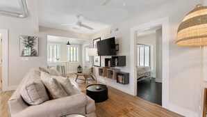 A modern living room with a sofa, coffee table, and a TV mounted on the wall.