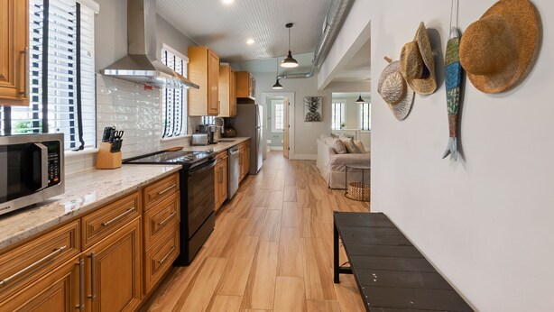 A spacious kitchen with wooden cabinets, a stainless steel microwave, and a large island.