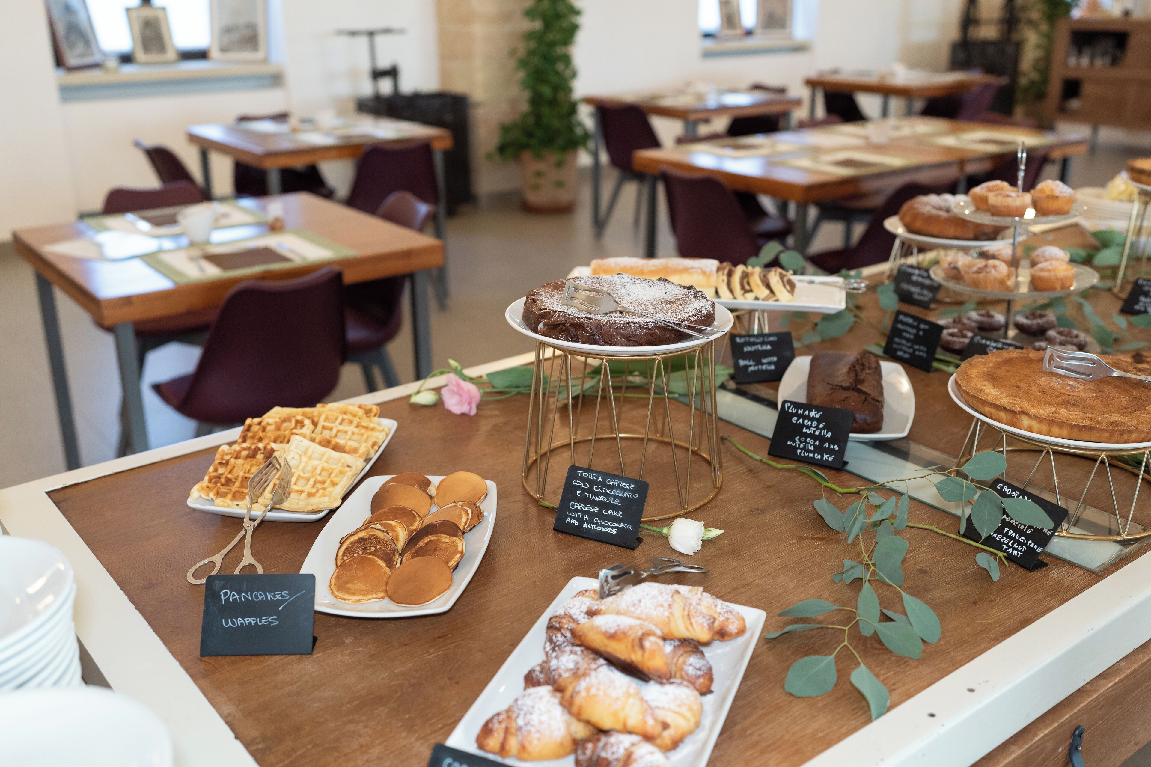 A bakery display with various pastries and waffles.