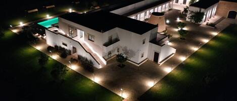 Une maison moderne à deux étages, dotée d’une piscine, d’allées bien éclairées et d’une cour intérieure.