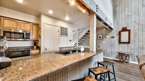 A kitchen with granite countertops, wooden cabinets, a stainless steel microwave, and a built-in oven. - Lakeland Village #481 - Family Footprints by the Lake-Sleeps 10 (South Lake Tahoe)