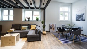 A modern living room with a sofa, coffee table, and dining area with chairs. - Wohnen im Milchhäusle von Schnait (Weinstadt)
