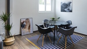 A modern dining area with a round table, black chairs, and a striped rug. - Wohnen im Milchhäusle von Schnait (Weinstadt)