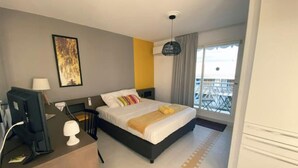 Une chambre d’hôtel avec un lit, un bureau et une vue sur l’extérieur.