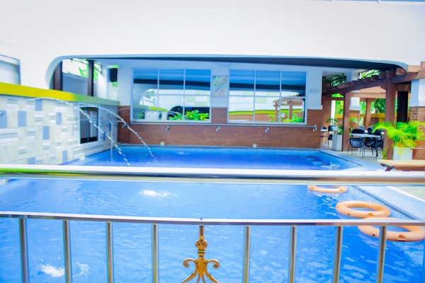 Una piscina al aire libre, sillones reclinables de piscina