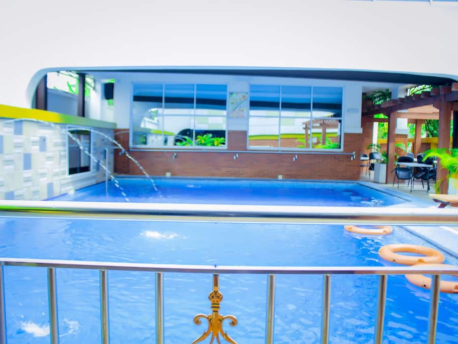 Una piscina al aire libre, sillones reclinables de piscina