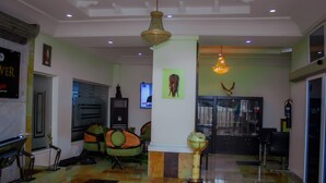 A lobby with a checkered floor, a globe, and a chandelier. - Forever Hotels and Suites (Owerri)