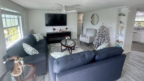 Una sala de estar con sofá, sillón y una pequeña mesa con un objeto decorativo.