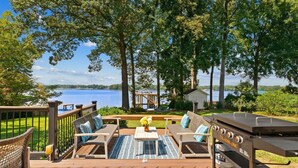 A deck with outdoor furniture, a grill, and a view of a lake. - Lakefront Living W/optional Boat Rental (Mooresville)