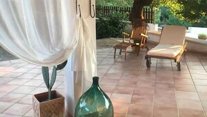 A patio area with a green vase, a chair, and a table. - The magical though (Puglia)