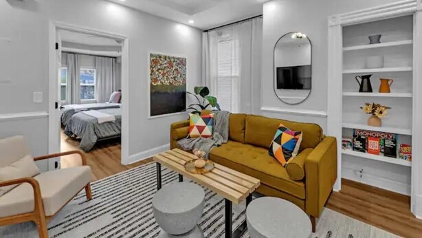 A modern living room with a sofa, coffee table, and a bookshelf.