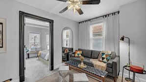 A modern living room with a grey sofa, a coffee table, and a ceiling fan.