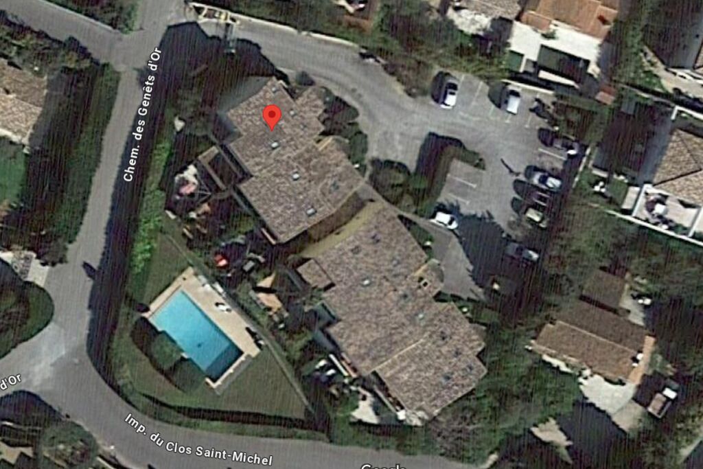 Ett flygbildsbild av ett bostadsområde med en swimmingpool, en röd markering och en väg som är skyltad med texten ”Imp. du Clos Saint-Michel”.