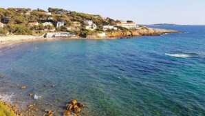 Une ville côtière aux eaux d’un bleu limpide, avec un littoral rocheux et des bâtiments construits sur une colline.