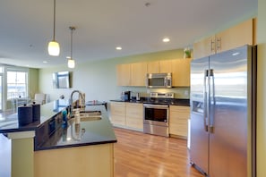 Enjoy cooking in this well-equipped kitchen with a refrigerator, microwave, double oven, and island with sink.