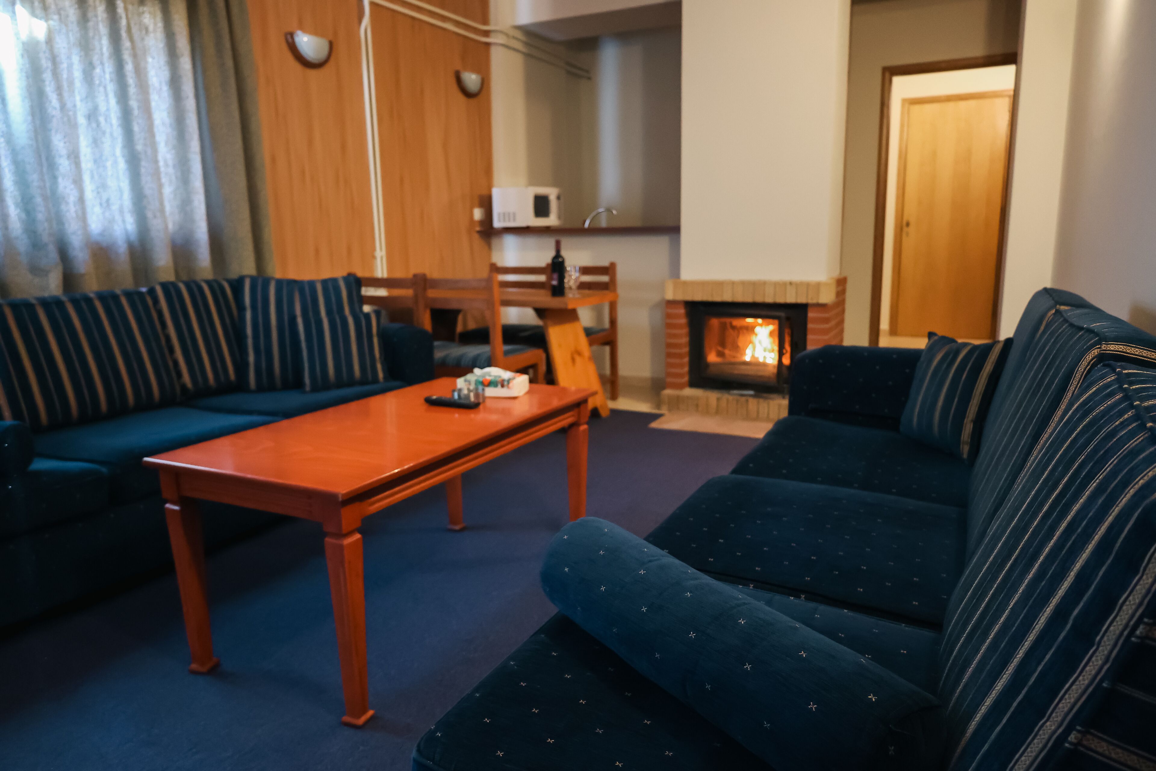Una sala de estar con sofá, una mesa de centro de madera y una chimenea.