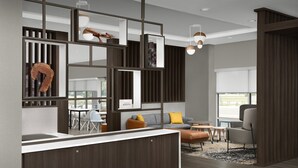 A modern interior with a kitchen area, a dining space, and a seating area with a sofa and chairs. - TownePlace Suites Jacksonville Airport (Jacksonville)