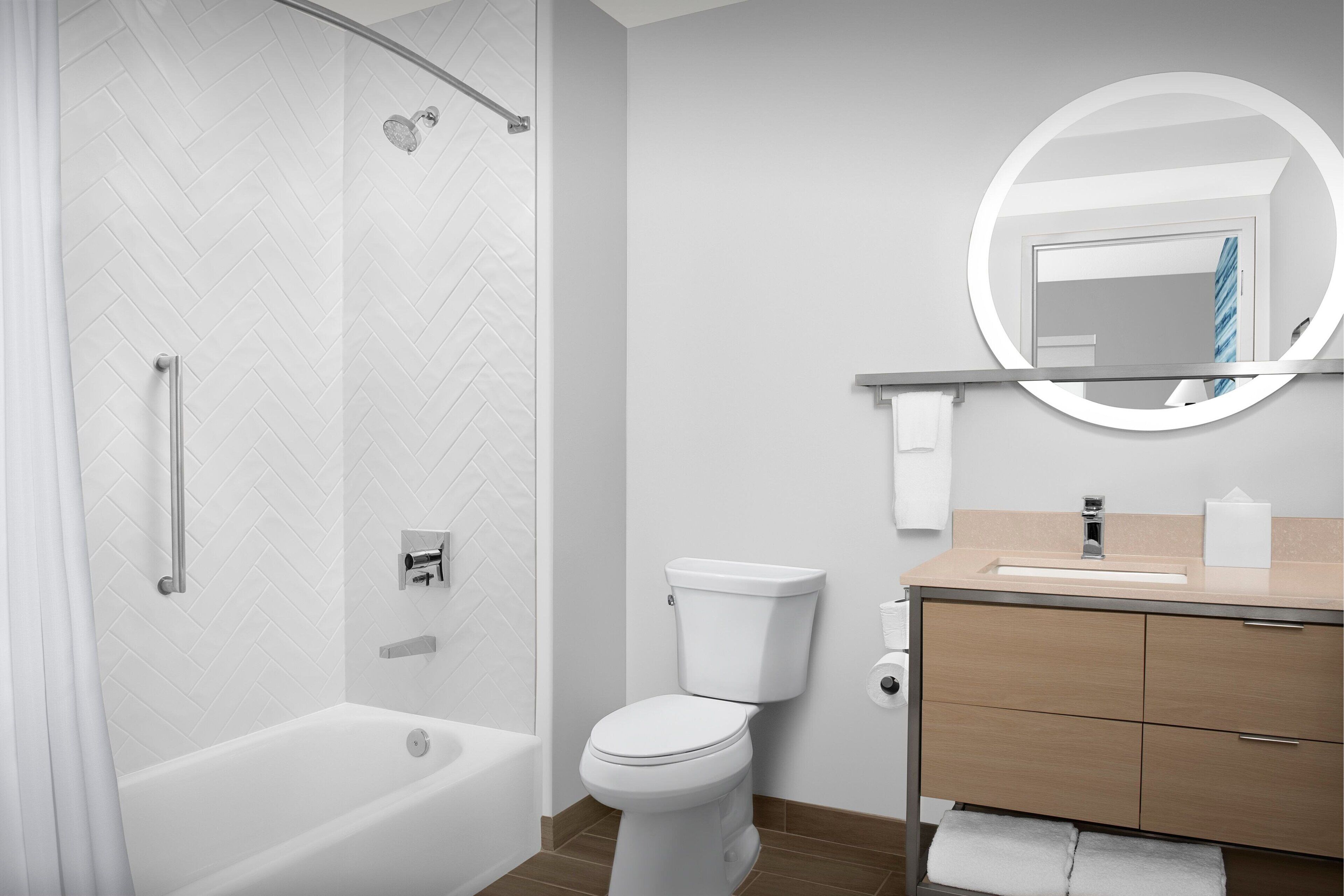 Une salle de bain moderne équipée d’une douche, de toilettes et d’un meuble-lavabo.