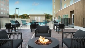 A rooftop patio with a fire pit, outdoor seating, and a swimming pool. - TownePlace Suites Jacksonville Airport (Jacksonville)