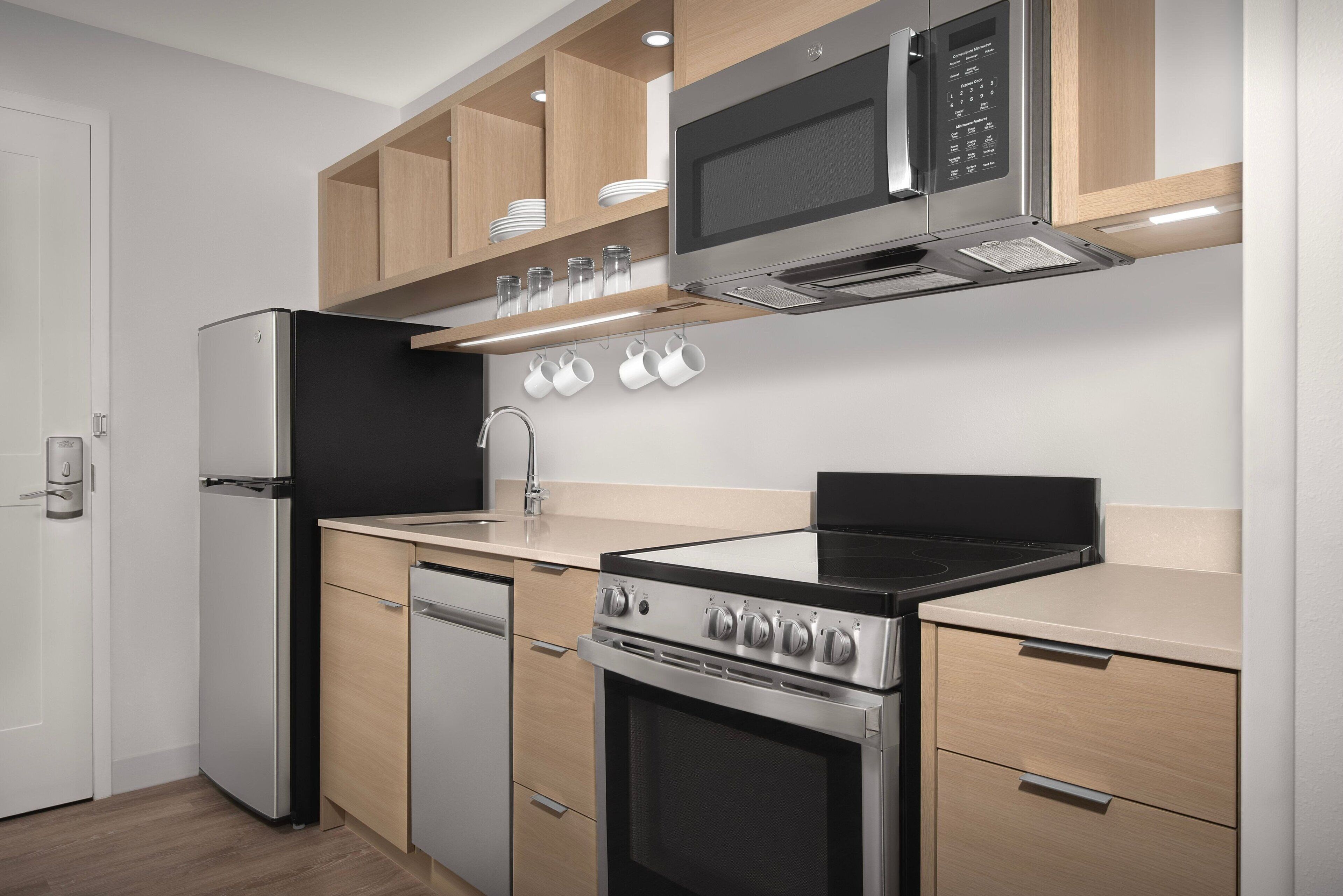A modern kitchen with a refrigerator, microwave, stove, and dishwasher.