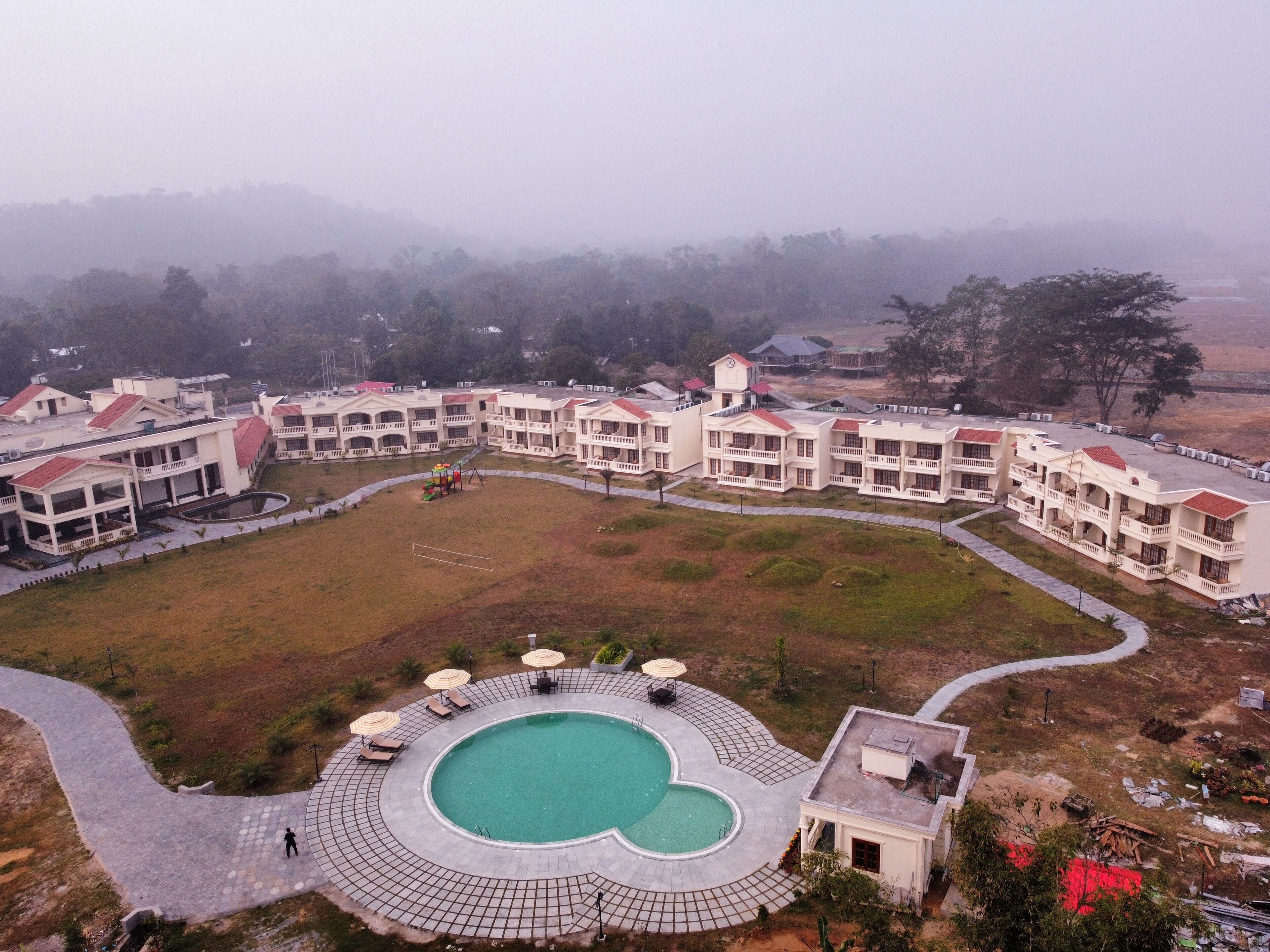 A hotel with a central courtyard, a swimming pool, and multiple buildings with balconies.