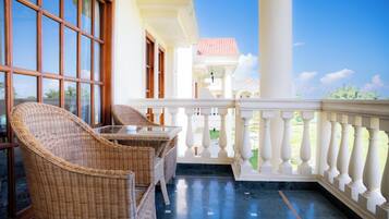 A balcony with wicker furniture and a view of the sky.