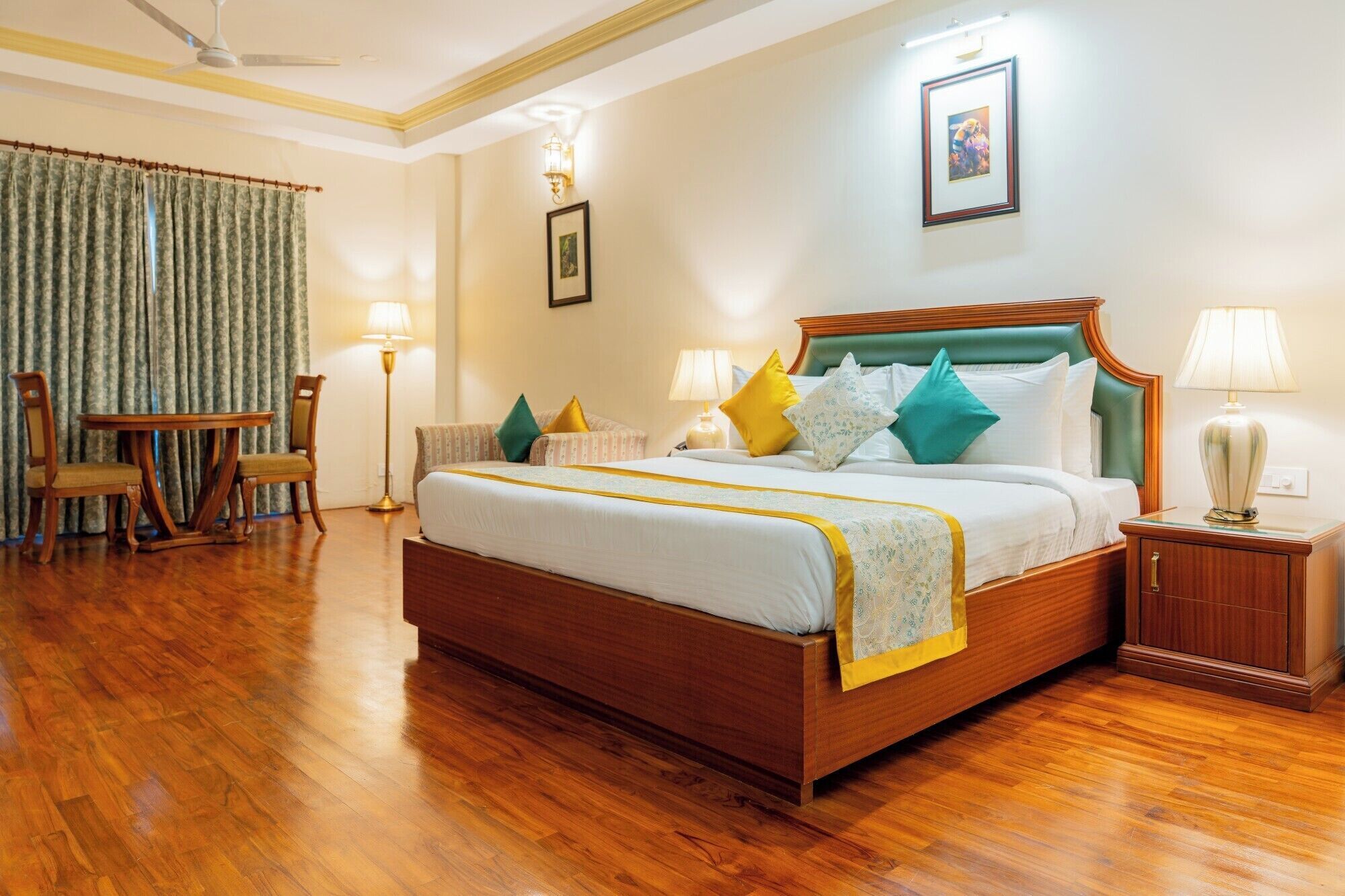 A hotel room with a wooden bed, two bedside tables, a chair, a floor lamp, and a picture on the wall.